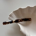 Dettaglio del fermaglio per capelli sottile in acetato tartarugato su vassoio a conchiglia - Tartarugato