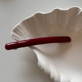 Vista macro dettagliata del fermaglio per capelli in acetato rosso su vassoio bianco - Rosso