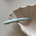 Detail of light blue marble acetate barrette with France lettering on shell bowl - Blue White