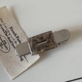 Detail of silver brushed metal hair clip featuring a marbled brown acetate inlay and logo - Khaki