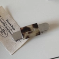 Detailed macro view of silver brushed hair clip with acetate leopard print and handmade logo - Tortoiseshell