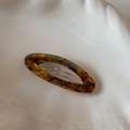 Detail of tortoise shell acetate hair clip with metal spring on a white plate - Blue Coffee