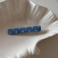 Détail d'une barrette à cheveux bleue à pois posée sur une assiette en céramique en coquillage - Denim Clair à Pois-Droit