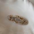 Macro shot of tortoise shell amber acetate hair clip with silver metal spring buckle - Apricot