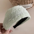 Gros plan détaillé du large bandeau en dentelle vert clair avec motif floral et bords doux - Vert