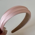 Vista dettagliata del cerchietto imbottito in raso rosa con trama a pieghe elegante - Rosa