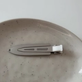 Sleek silver metal hair clip with geometric lines on a ceramic tray minimalist style - Gun Grey