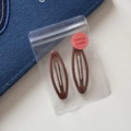 Close-up of brown leopard pattern snap hair clips in a branded clear gift bag - Oval Hollow BB - Brown (6cm)