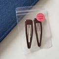Detail of two dark brown leopard print BB clips in transparent packaging on denim - Triangle Hollow BB - Solid Brown (6.6cm)