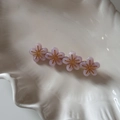 Détail de barrettes à fleurs en résine rose dans un plateau en céramique blanche - Rose Clair