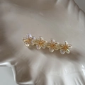 Vue détaillée d'une pince à cheveux à quatre fleurs nacrées sur un plateau coquillage - Blanc Transparent