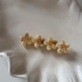 Détail de quatre barrettes à fleurs en acétate avec texture marbrée et centre doré - Abricot Beige