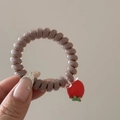 Détail d'un élastique à cheveux en fil de téléphone avec pendentif tomate cerise rouge - Petite Tomate