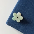 Detailweergave van een lichtgroene bloem haarklem met strass op denim stof - Groen