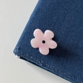 Macro-opname van roze bloem haarklem met edelsteen op blauwe denim achtergrond - Roze