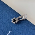Dettaglio del fermaglio per capelli a fiore in metallo argento con perla nera su denim - Fermaglio Fiore Metallico - Fiore Argento (FJ892422)