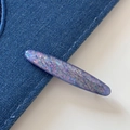 Detail view of purple oval glitter hair clip with shell cat-eye effect on denim fabric - Shell Sequin Side Clip-Purple