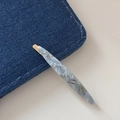 Macro detail of marble pattern acetate hair clip with gold handmade inscription - Blue Marble