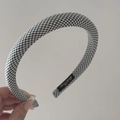 Detail of padded black and white checkered headband featuring a premium inner brand label - Headband / Black and White Plaid