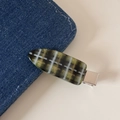 Dettaglio di un fermaglio per capelli a scacchi verde e bianco su tessuto in denim - Color Caramella Plaid - Verde Scuro