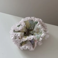 Gros plan d'un chouchou floral avec bords à volants blancs et motifs de fleurs pastel - Frais à Volants Grand-Rose