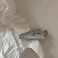 Dettaglio fermaglio per capelli a fiore argento con strass blu e base triangolare in metallo - Stile Triangolo