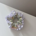 Gros plan d'un chouchou floral avec motifs de fleurs pastel et bords à volants blancs - Frais à Volants Petit-Violet