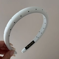 Detail shot of white polka dot fabric headband featuring a woven inner brand label - Narrow Headband / Blue