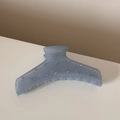 Détail d'une pince à cheveux bleue translucide avec des strass et un ressort métallique - Bleu