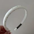 Detail of white and black polka dot headband showing fabric texture and inner brand label - Narrow Headband / White
