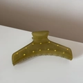 Gros plan sur la pince à cheveux vert olive avec strass dorés étincelants - Vert olive