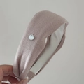 Détail d'un bandeau en maille rose poudré avec pendentif coeur argenté et doublure en tissu - Rose