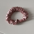 Détail d'un chouchou en satin rose avec texture en soie et boucle en plastique durable - Rose