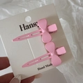 Gros plan d'une paire de barrettes à nœud rose sur carte d'affichage faite main - Rose Clair