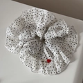 Dettaglio di scrunchie bianco a pois con bordi a balze ed etichetta a cuore artigianale - Bianco