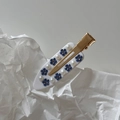 Detail of a white acetate hair clip with blue rhinestone flowers and faux pearls - White Flower