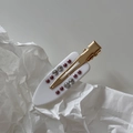 Detail of white acetate hair clip with gold metal base and sparkling crystal rhinestones - Clear Micro-pave