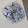 Detail of blue striped scrunchie with red bow embroidery on a minimalist background - Blue Striped - Bow