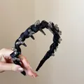 Dettaglio di cerchietto nero intrecciato con cristalli grigio fumo e dentini antiscivolo - Nero