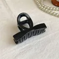 Dettaglio della molletta per capelli a fiocco in resina nera con molla in metallo - Superficie Lucida Nera
