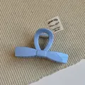 Detail view of a glossy light blue bow hair claw clip with a strong metal spring - Blue Bow