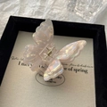Detail of iridescent double-layered butterfly hair claw clip with golden metal spring - AB White