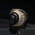 Detailed close-up of retro punk titanium steel ring with black oval gem and gold carving - Two-Tone Black Gem