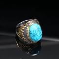 Macro detail of vintage punk titanium ring with green turquoise and gold flame reliefs - Gold-Silver Turquoise