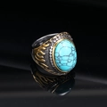 Macro detail of men's vintage punk ring featuring a green stone and golden flame patterns - Two-Tone Green Turquoise