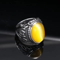 Macro shot of punk flame-patterned titanium steel ring with yellow cat-eye gemstone - Steel Tone Yellow Cat's Eye