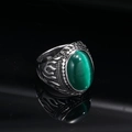 Macro shot of vintage titanium ring with green cat eye gemstone and flame carvings - Silver Green Cat's Eye