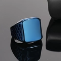 Detail of blue signet ring with square face and honeycomb cutout texture on black surface - Blue