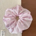 Close-up of pink polka dot chiffon scrunchie with soft pleated texture and elastic band - Pink Polka Dot