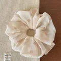 Detail view of beige mesh scrunchie with pink polka dots on soft fabric surface - Beige Polka Dot